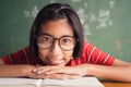 Asian girl with glasses is smiling and reading a book in class on  blackboard Royalty Free Stock Photo