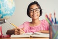 Asian girl with glasses is taking notes in her class notebook, Educational concept