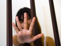Asian Girl and hand behind bars