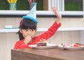 Asian girl happy eating her birthday cake, asking for more ca Royalty Free Stock Photo