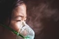 Asian girl has asthma or pneumonia disease and need nebulization by get inhaler mask on her face Royalty Free Stock Photo