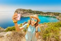 Girl in a hat takes a selfie on the background of stunning views of the azure Bay in the Mediterranean sea. Travel, vacation