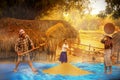 An Asian girl helps his mother to work after returning from school. Grain separation. girl and buffalo. Rural families are