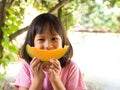 Asian girl holding slice orange melon on hands. Look like melon