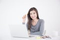 Asian girl holding yellow pencil in hand and using laptop,Female smiling happily working in a white office desk Royalty Free Stock Photo