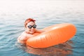 Asian girl with inflatable ring having fun and swimming at a popular sea resort. Vacation and safety concept