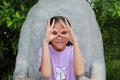 Asian girl kid looking at camera through fingers in binocular gesture Royalty Free Stock Photo