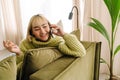 Asian girl laughing and talking on cellphone while resting on sofa