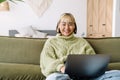 Asian girl laughing and working with laptop while resting on sofa Royalty Free Stock Photo