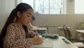 Asian girl learning in classroom. Student writing in notebook during lesson Royalty Free Stock Photo