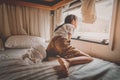 Asian girl looking out the windows for hope after been quarantine in a trailer home for a long time