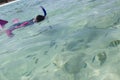 Asian girl looks at fish while snorkelling