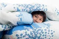 Asian girl lying under a blanket in the bed Royalty Free Stock Photo