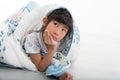 Asian girl lying under a blanket in the bed Royalty Free Stock Photo