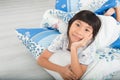 Asian girl lying under a blanket in the bed Royalty Free Stock Photo