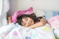 Asian girl lying under a blanket in the bed Royalty Free Stock Photo