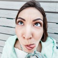 Asian girl make funny faces. Millennials emotions. Wide-angle optics and fisheye distortion Royalty Free Stock Photo