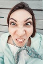Girl make funny faces and grimaces. Millennials emotions. Wide-angle optics and fisheye distortion