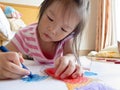 Asian girl Painting crayon on large sheets of paper On the floor