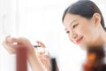 Asian girl with perfume, young woman applying perfume on her wrist and  smelling. Royalty Free Stock Photo