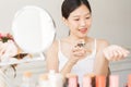 Asian girl with perfume, young woman applying perfume on her wrist and  smelling. Royalty Free Stock Photo