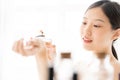 Asian girl with perfume, young woman applying perfume on her wrist and  smelling. Royalty Free Stock Photo