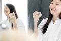 Asian girl with perfume, young woman applying perfume on her wrist and  smelling. Royalty Free Stock Photo