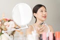 Asian girl with perfume, young woman applying perfume on her wrist and  smelling. Royalty Free Stock Photo
