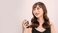 Asian girl with perfume, young woman applying perfume on her wrist and smelling Royalty Free Stock Photo