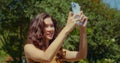 Asian girl photographing landscape in park closeup. Woman using smartphone. Royalty Free Stock Photo