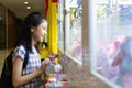 Asian girl playing Claw Game or cabinet catches the doll at one