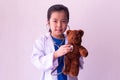 Asian girl playing doctor and listening teddy bear with stethoscope Royalty Free Stock Photo