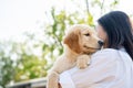 Asian girl playing and embracing her four-legged friend lovingly in the park