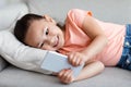 Asian Girl Playing Game On Phone Lying On Couch Indoor Royalty Free Stock Photo