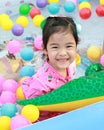 Asian girl playing in a pool with colorful balls Royalty Free Stock Photo