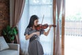 Asian girl playing the violin alone in the room Royalty Free Stock Photo