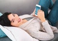 Asian girl, portrait and phone on sofa with news search, reading or checking weather app at home. Smartphone, streaming Royalty Free Stock Photo