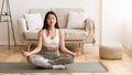Asian Girl Practicing Yoga In Lotus Position at Home Royalty Free Stock Photo