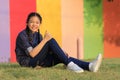 Asian girl relaxing sitting on green grass field of public park Royalty Free Stock Photo