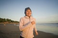 Asian girl running on the beach - young attractive and happy Korean woman doing jogging workout at beautiful beach enjoying Royalty Free Stock Photo