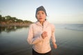Asian girl running on the beach - young attractive and happy Korean woman doing jogging workout at beautiful beach enjoying Royalty Free Stock Photo
