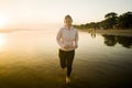 Asian girl running on the beach - young attractive and happy Korean woman doing jogging workout at beautiful beach enjoying Royalty Free Stock Photo