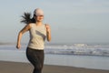 Asian girl running on the beach - young attractive and happy Korean woman doing jogging workout at beautiful beach enjoying Royalty Free Stock Photo