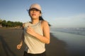 Asian girl running on the beach - young attractive and happy Korean woman doing jogging workout at beautiful beach enjoying Royalty Free Stock Photo