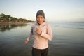 Asian girl running on the beach - young attractive and happy Korean woman doing jogging workout at beautiful beach enjoying Royalty Free Stock Photo