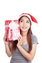 Asian girl with santa hat think what inside a gift box