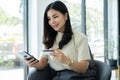 Asian girl shopping online holding credit and using smartphone enter their card number in the mobile phone app to purchase and Royalty Free Stock Photo