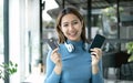 Asian girl shopping online holding credit and using smartphone enter their card number in the mobile phone app to purchase and Royalty Free Stock Photo