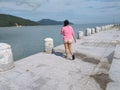 asian girl in shorts walking by the pier on sunny afternoon