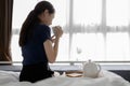 Asian girl sitting on bed drinking hot beverage in the morning,female hold the cup of herbal tea,inhales the smell and smiling Royalty Free Stock Photo